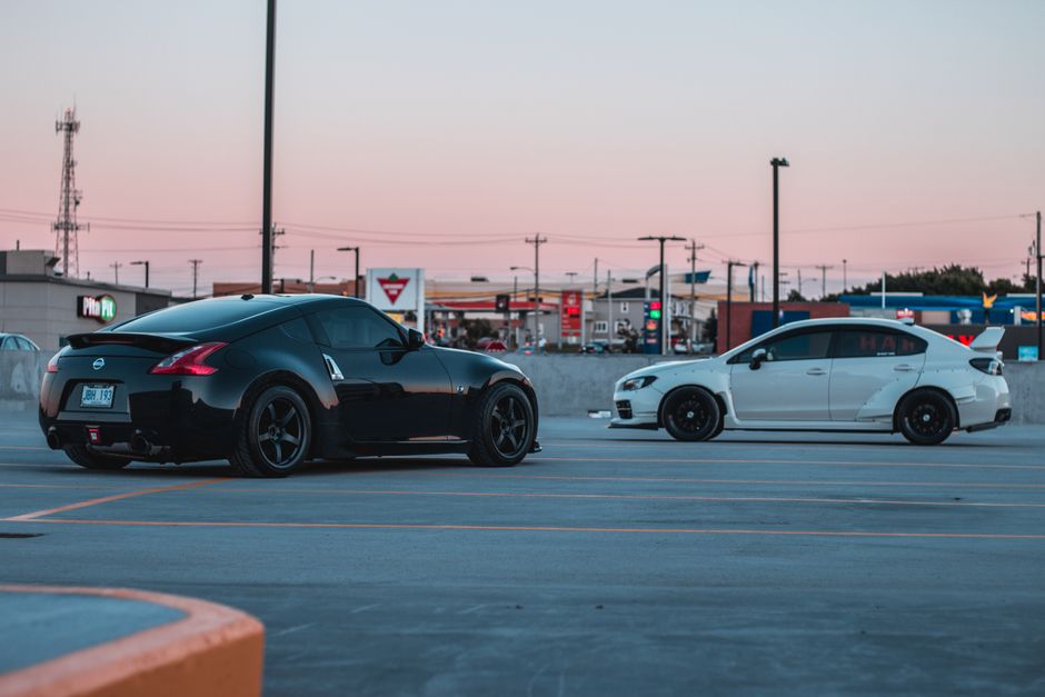 Stylish black and white sports cars parked on asphalt parking area