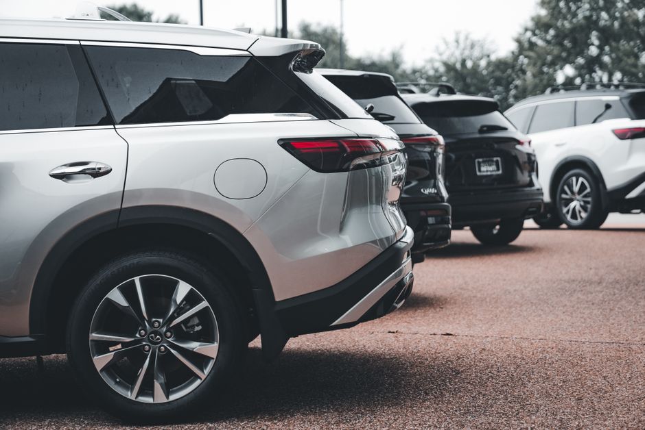 A row of parked SUVs including a silver Infiniti QX60 in an outdoor setting