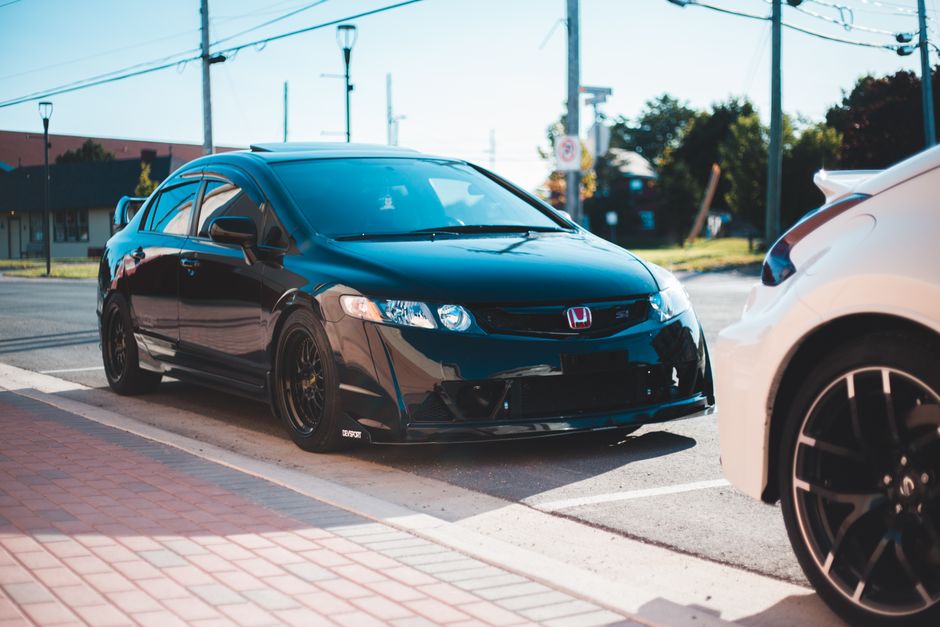 Black vehicle parked on asphalt road in city street