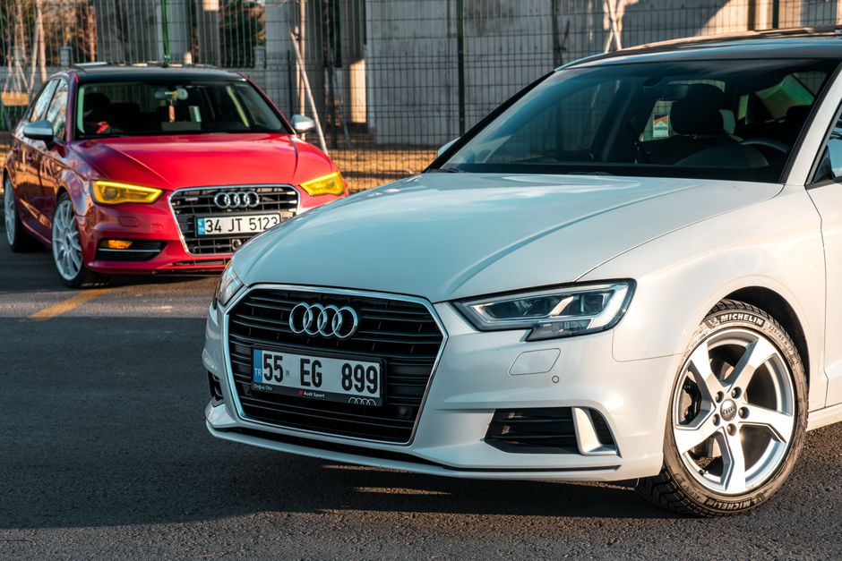 Two Audi cars parked in the daylight, showcasing sleek design and style