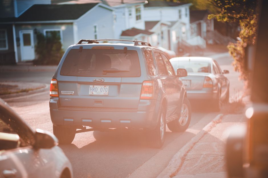 A blue SUV parked along a quiet residential street